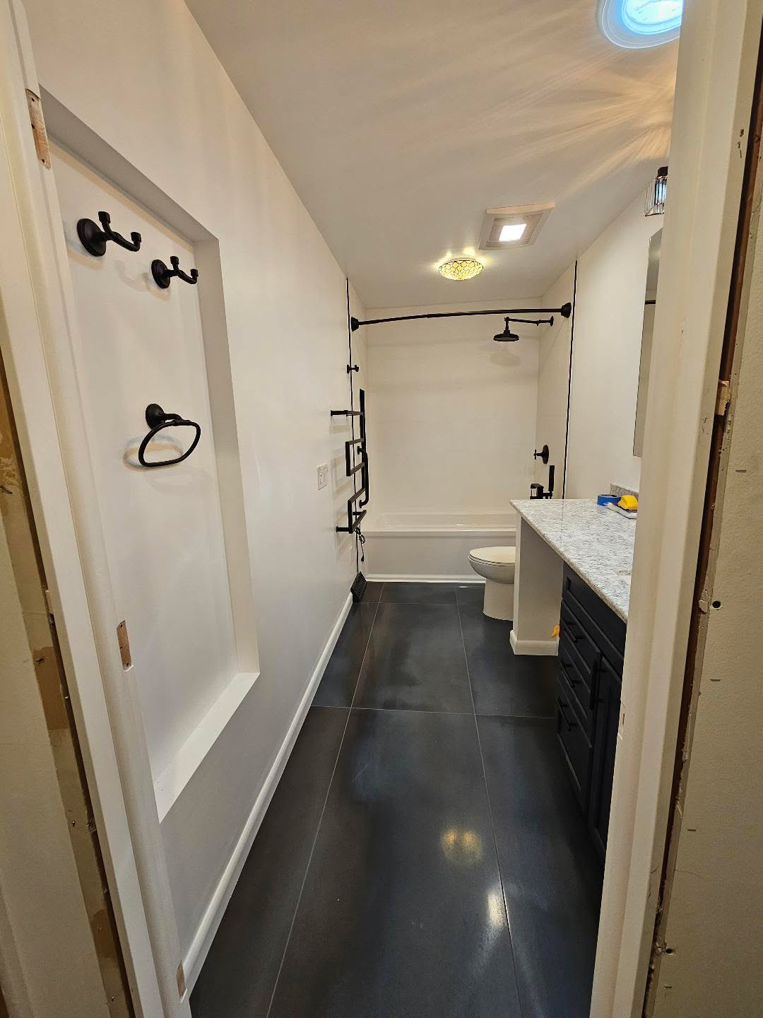 Full bathroom with dark large format floor